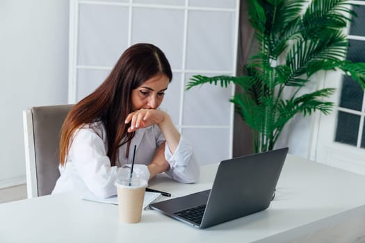 woman working online with laptop at desk in office