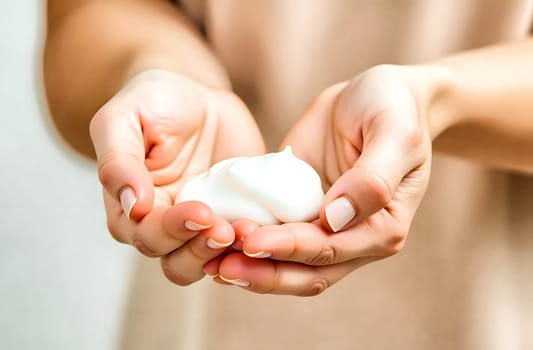 Hands are gently applying a creamy foam to the skin, showcasing a personal care routine focused on hydration and nourishment.
