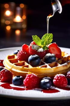 Golden waffles drizzled with rich syrup, topped with fresh strawberries, blueberries, and raspberries. Garnished with mint leaves, creating an inviting breakfast scene perfect for food lovers
