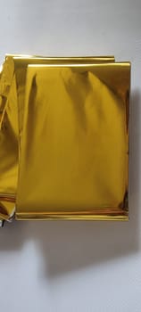 thin gold foil aluminum blanket background AliExpress souvenir texture, emergency blanket, abstract object on white background
