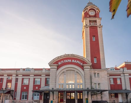Historic Varna Railway Station in Bulgaria with its iconic clock tower, elegant architecture, and warm sunset glow.