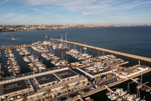 Aerial drone shot of sailboats on sea at marina in Cascais city of Portugal. From above view of crowded harbor at famous destination.