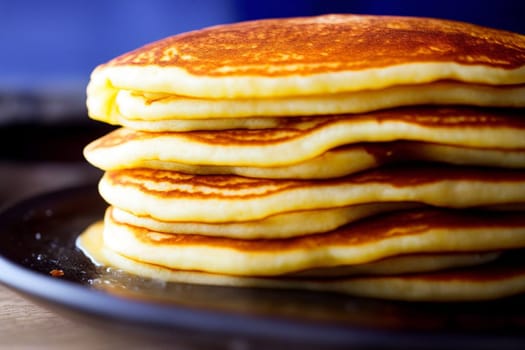 Pancakes stacked on top of each other on a plate. The pancakes are golden brown and look delicious