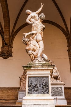 Florence, Italy, January 4, 2024: Copy of the sculptural group of the Rape of the Sabinas, the work of Giambologna, in the loggia dei Lanzi, in the Piazza della Signoria in Florence. Front view