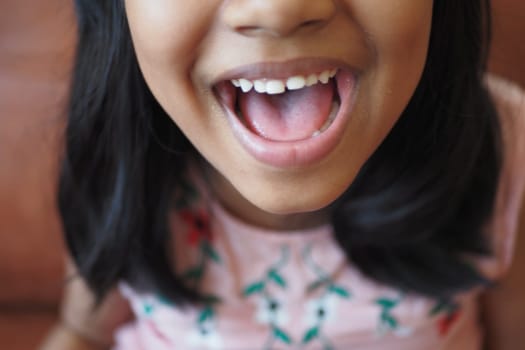 A cheerful girl smiles widely, capturing a moment of pure happiness and innocence