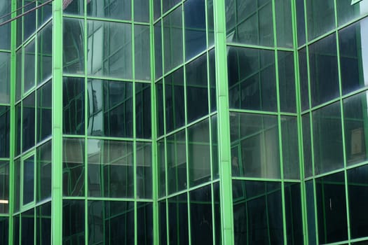 A beautiful green glass design vibrantly reflects light within modern urban architecture