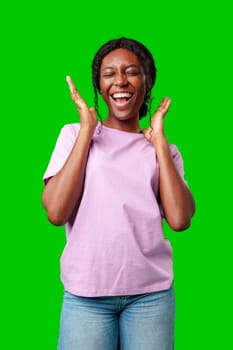 Young woman smiling joyfully in a pink shirt against a vibrant green background in a cheerful atmosphere close up
