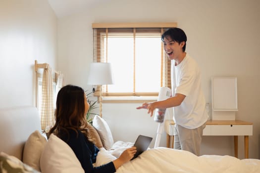 Happy adult couple enjoying time together in a cozy bedroom.