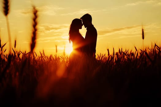 A couple standing in a wheat field, holding each other close as the sun sets in the background., silhouette --ar 3:2 --v 6.1 Job ID: 0e493cde-eeab-4aeb-a022-5116b501e8a7