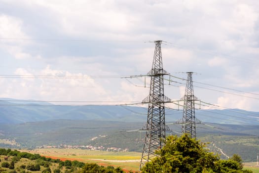 High voltage towers Electric pole. Power line support with wires for electricity transmission. High voltage grid tower with wire cable at distribution station. Energy industry, energy saving.