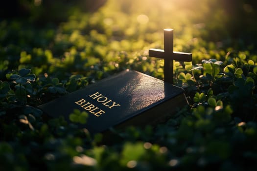 a bible book and a cross lying on the green clover leaves..