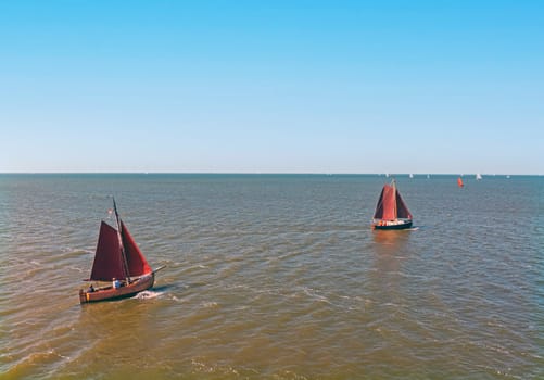 Aerial from old wooden sailing boats cruising on the IJsselmeer in the Netherlands