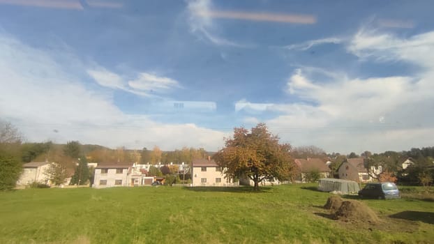 autumn landscape nature, green grass plain trees, gray blue sky white clouds houses.High quality photo