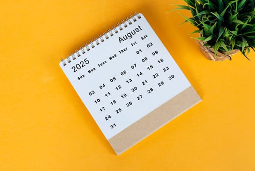August 2025 desk calendar on yellow background. Directly above. Flat lay. Copy space.