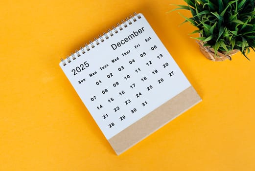 December 2025 desk calendar on yellow background. Directly above. Flat lay. Copy space.