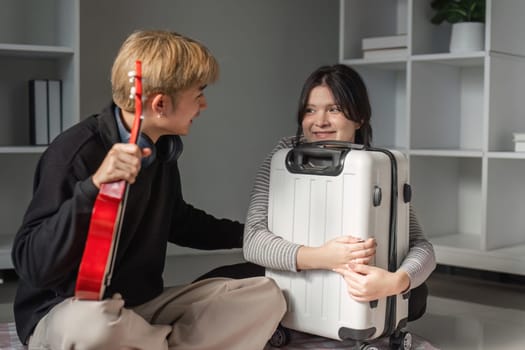 A young couple joyfully prepares their suitcases for an upcoming trip, symbolizing excitement and adventure.