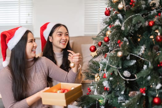 Two happy young women celebrating Christmas, enjoying festive decorations and holiday cheer.