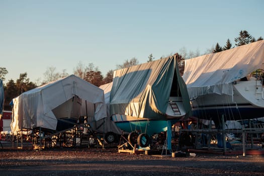 Sailboats are covered, protected and stored out of the water for the winter, winter storage for the sailboat in Finland, winterizing
