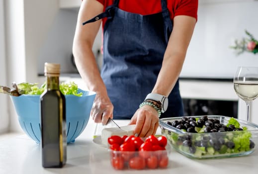 Girl Cuts Feta Cheese For Greek Salad, Preparing Food At Home In Kitchen