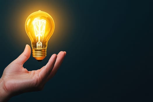 A hand holds a bright light bulb that radiates a warm glow, symbolizing creativity and inspiration. This image captures the essence of innovative ideas and bright visions.