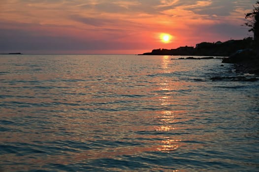 Beautiful sunset on the beach with the sea. Waves on the sea. Greece - Corfu island (Kerkyra) Agios Georgios. A concept for travel, holidays and summer vacations. 