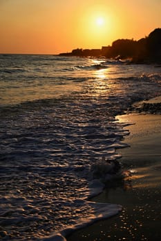 Beautiful sunset on the beach with the sea. Waves on the sea. Greece - Corfu island (Kerkyra) Agios Georgios. A concept for travel, holidays and summer vacations. 