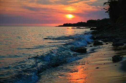 Beautiful sunset on the beach with the sea. Waves on the sea. Greece - Corfu island (Kerkyra) Agios Georgios. A concept for travel, holidays and summer vacations. 