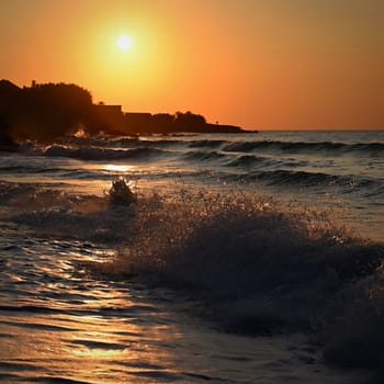 Beautiful sunset on the beach with the sea. Waves on the sea. Greece - Corfu island (Kerkyra) Agios Georgios. A concept for travel, holidays and summer vacations. 