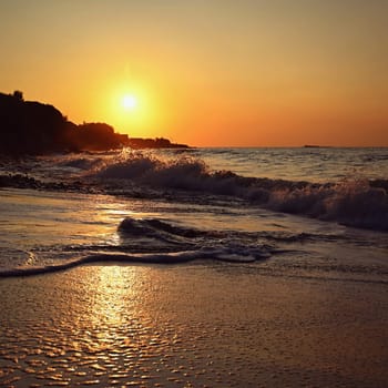 Beautiful sunset on the beach with the sea. Waves on the sea. Greece - Corfu island (Kerkyra) Agios Georgios. A concept for travel, holidays and summer vacations. 