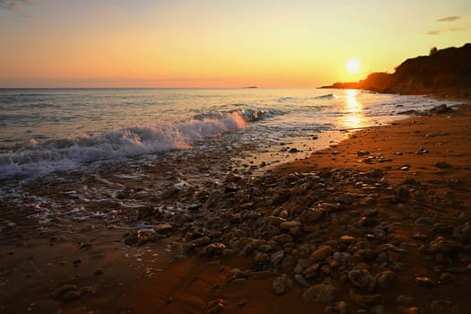 Beautiful sunset on the beach with the sea. Greece - island of Corfu (Kerkyra). Concept for travel, holidays and summer vacations. 