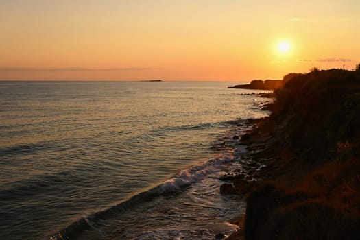 Beautiful sunset on the beach with the sea. Greece - island of Corfu (Kerkyra). Concept for travel, holidays and summer vacations. 