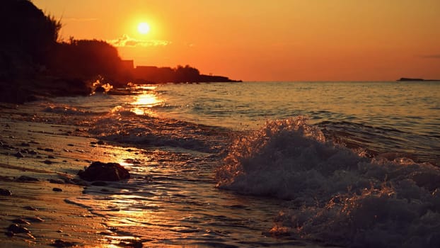 Beautiful sunset on the beach with the sea. Greece - island of Corfu (Kerkyra). Concept for travel, holidays and summer vacations. 