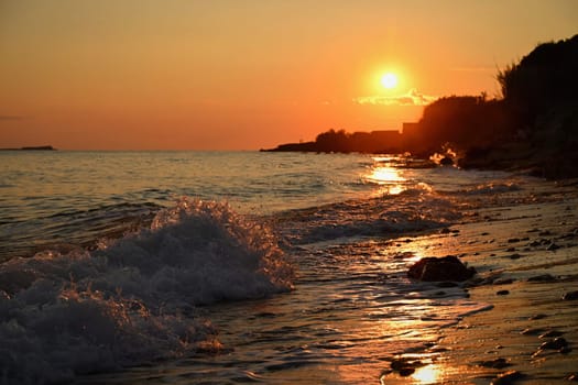 Beautiful sunset on the beach with the sea. Greece - island of Corfu (Kerkyra). Concept for travel, holidays and summer vacations. 