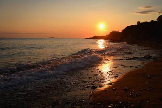 Beautiful sunset on the beach with the sea. Greece - island of Corfu (Kerkyra). Concept for travel, holidays and summer vacations. 