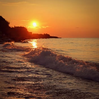 Beautiful sunset on the beach with the sea. Greece - island of Corfu (Kerkyra). Concept for travel, holidays and summer vacations. 