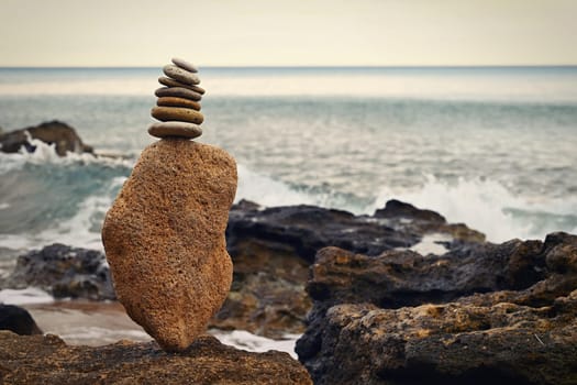 Mounds of stones on the beach by the sea at sunset. A concept for travel, summer holidays and relaxation. 