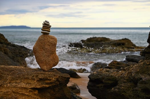 Mounds of stones on the beach by the sea at sunset. A concept for travel, summer holidays and relaxation. 