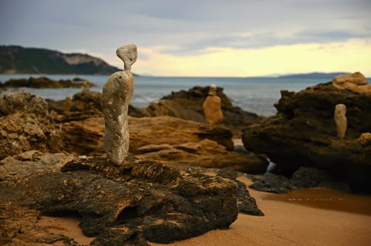 Mounds of stones on the beach by the sea at sunset. A concept for travel, summer holidays and relaxation. 