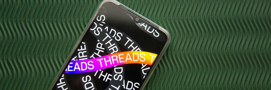 Tver, Russia - July 15, 2023, threads logo on the smartphone screen, on a green background. The threads icon. The logo of the current application. Threads social network