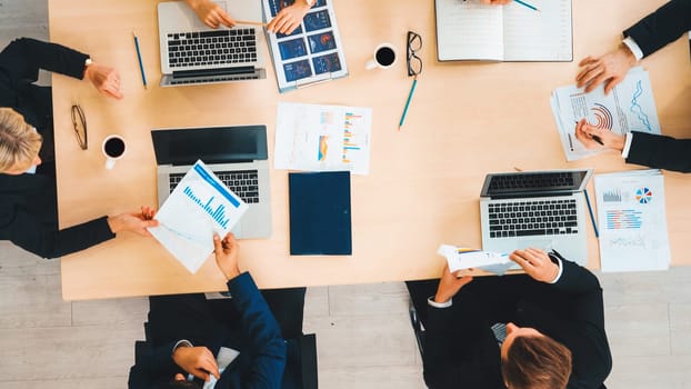 Business people group meeting shot from top view in office . Profession businesswomen, businessmen and office workers working in team conference with project planning document on meeting table . Jivy