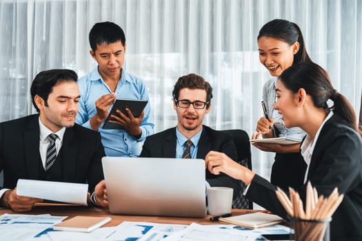 Diverse of business people from various ethnic group working in modern office environment. Productive and multi ethnic office workers engage in discussion for strategic business marketing. Meticulous