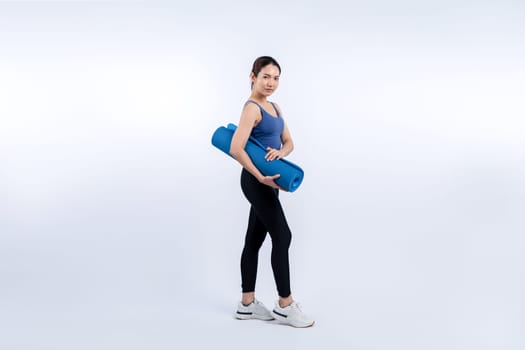 Young attractive asian woman portrait in sportswear with exercising mat. Healthy exercise and workout routine lifestyle concept. Studio shot isolated background. Vigorous