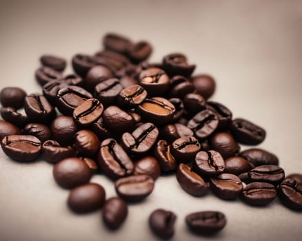 A pile of coffee beans with the beans spread out on a table. The beans are of different sizes and shapes, and they are all brown in color. Concept of warmth and comfort