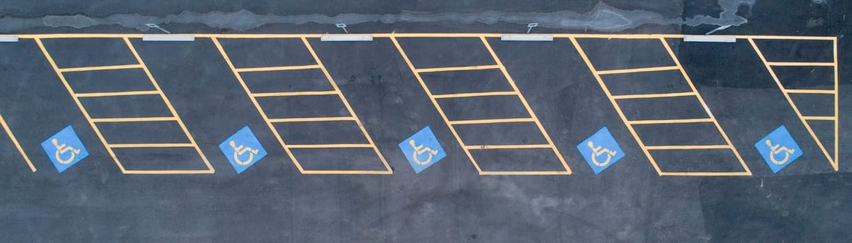 A parking lot with handicap parking spaces. The handicap parking spaces are marked with blue signs