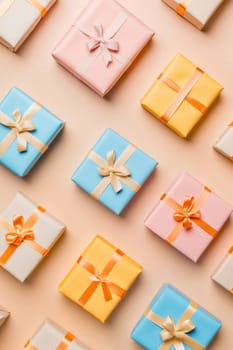 Small gift boxes tied with colorful ribbons are creating a beautiful festive pattern, ideal for celebrations and special occasions