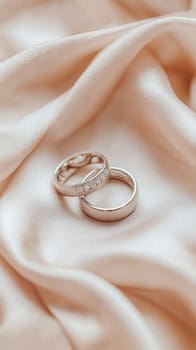 Wedding rings showcasing everlasting love and commitment, placed on a luxurious peach satin background
