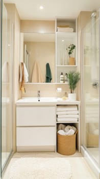 Bright, clean, and modern bathroom showcasing minimalist design with white fixtures, organized towels, and a touch of greenery