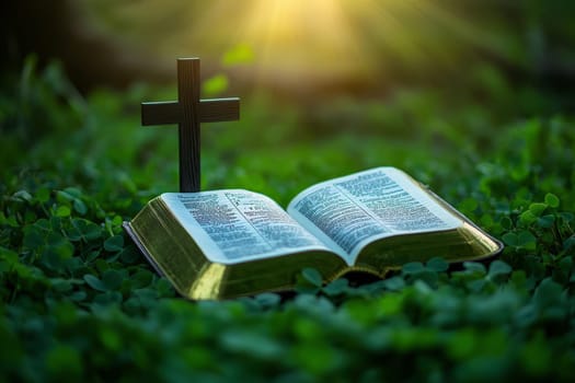 a bible book and a cross lying on the green clover leaves..