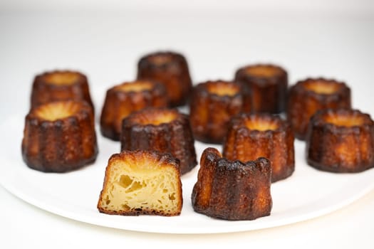 Caneles de bordeaux, traditional French sweet dessert with white table background, High quality photo