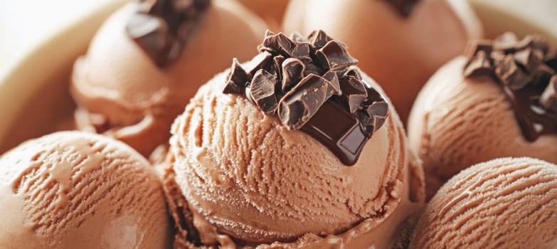 Close up of chocolate ice cream scoops, topped with chocolate shavings and chocolate sauce, creating a decadent dessert
